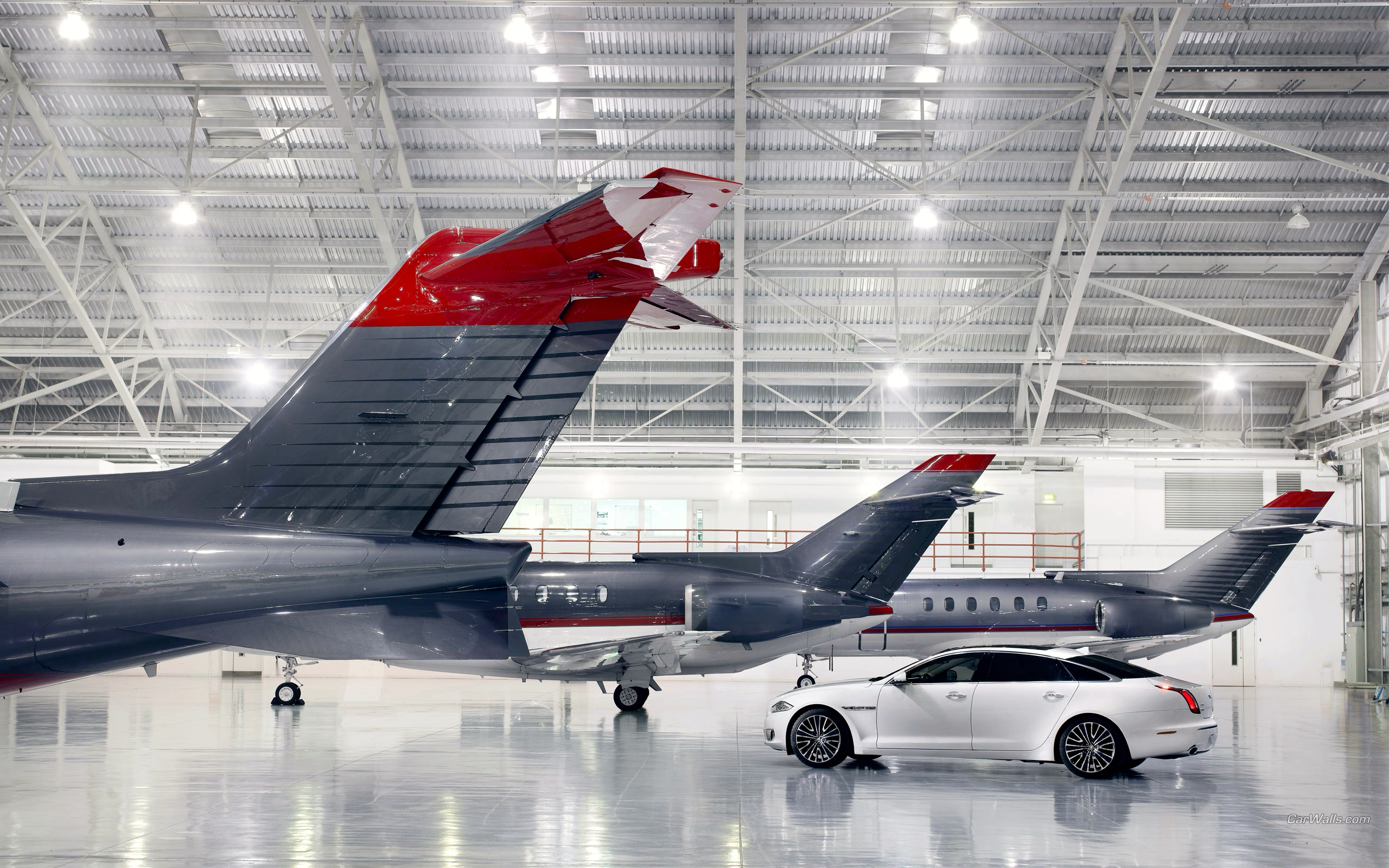 Chaffeur Service hangar Angar in aeroporto privato con tre jet privati per il noleggio e auto a disposizione per prenotare transfer aeroportuali con noleggio con autista