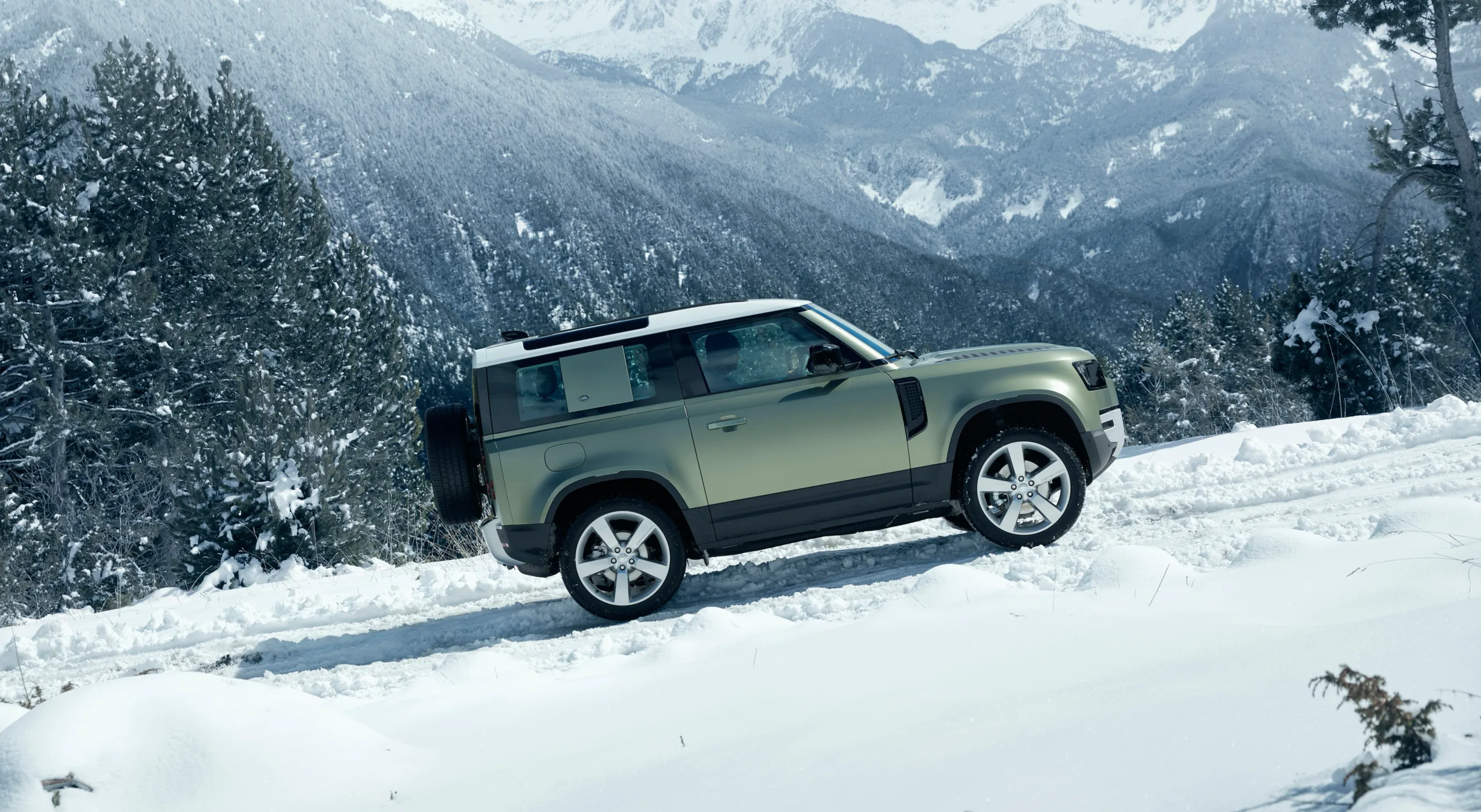 Range Rover Defender V8 Supercharged a noleggio su strada alpina innevata con consegna in aeroporto