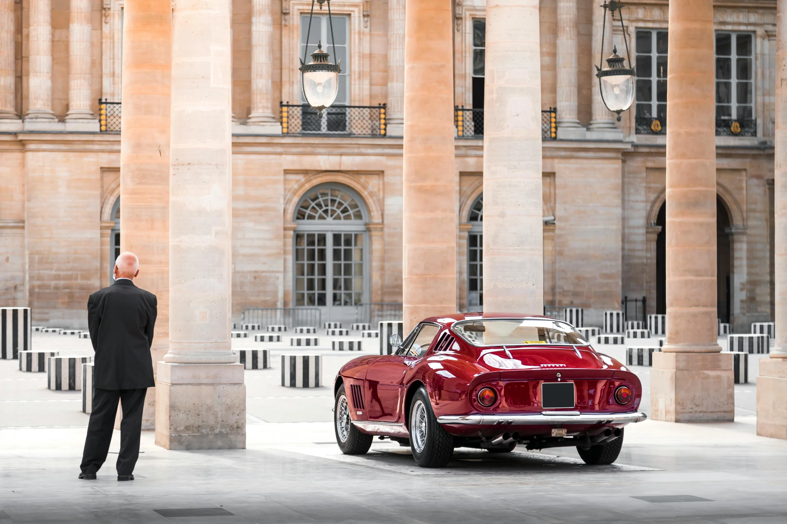uomo osserva Ferrari classica in contesto architettonico elegante durante tour in supercar in Europa